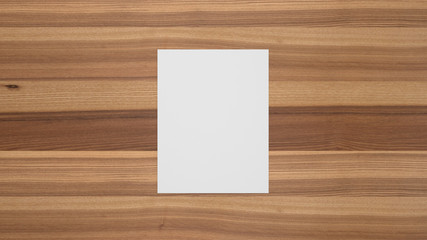 Blank portrait sheet of paper on brown ash wood table