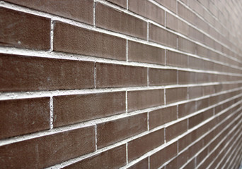perspective of a big brick wall with dark brown and white color - regular and well aligned bricks background wallpaper