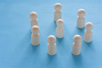 Woman figure surrounded by a circle of mans silhouettes on blue background. Gender discrimination and sexual violence concept. Female leader boss in a male team.