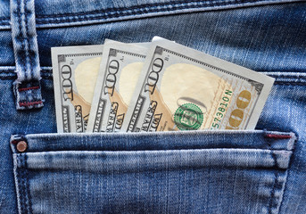 Dollars in a jeans pocket. The hand that takes money out of pocket.