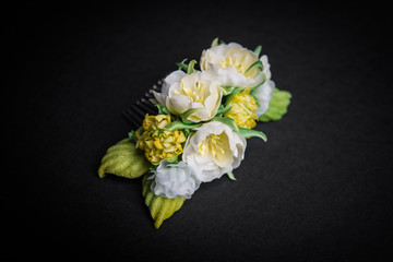 Wedding hair pin decorated with artificial flowers on black background