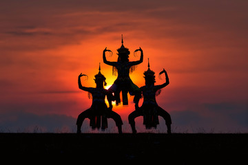 The black silhouette of three Manohra actors dancing in the park in the evening. Manohra performance is a folk dance that has a long history in southern Thailand.