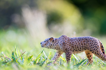 夏の公園の芝生においてある可愛い動物のフィギュア模型