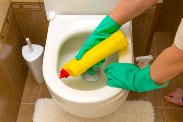 a woman cleans the toilet