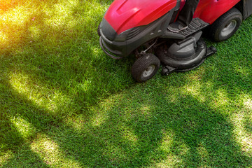 Top down above view of professional lawn mower worker cutting fresh green grass with landcaping...