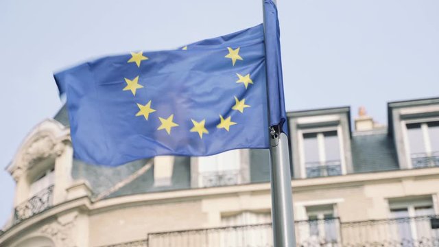 European Union flag waving in the wind with Parisian roof in the background 4K