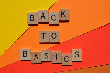 Back to Basics in wooden alphabet letters  isolated on orange and red background