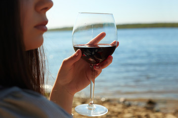 girl on the beach holding a glass of red wine