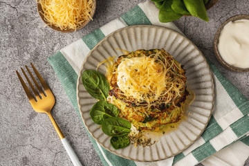 zucchini and spinach pancakes with cheese and sour cream, top view