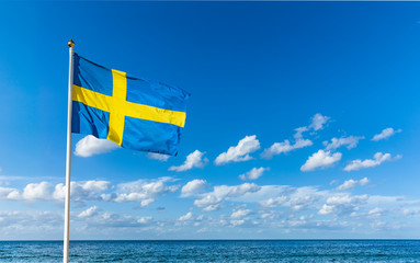Schwedische Flagge im Wind vor Blauem Himmel