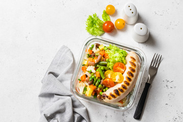 Healthy meal prep, salad and protein, Grilled sausage and steamed vegetables in glass bowl. Top view, space for text.