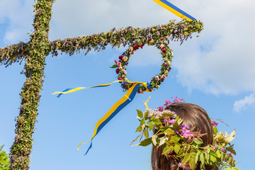Mit Blumenkranz am Mittsommerbaum in Schweden