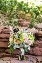 pink and green wedding bouquet with succulents in front of red rock