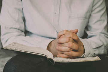 Reading the bible. Prayer. Hands folded in prayer concept. The concept of faith