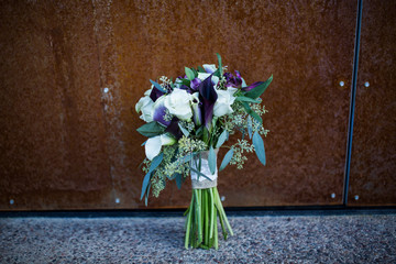wedding bouquet leaning against orange rusty wall with copy space
