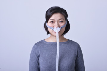 Young woman is wearing a nasal pillow ventilator mask during COVID-19 outbreak
