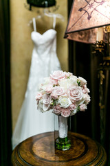 wedding bouquet with white wedding dress in background