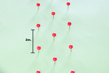 Thumbtacks two meters away. Social distancing concept.