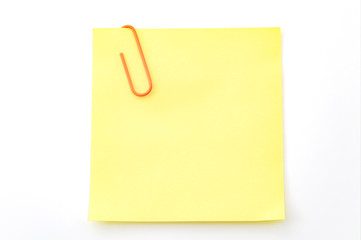 Office memo and reminder note concept with blank self adhesive yellow sticky note with paperclip isolated on white background with copy space and clipping path cutout