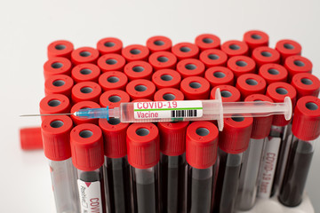 Syringe with vaccine against Covid-19 virus on pack with blood tests. Scientists created treatment...