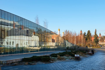 Fototapeta premium The Zaryadye Park. Varvarka Street. The Varvarinskaya Church, the old English courtyard and the Moscow Kremlin reflected in a glass facade of the house 6, Building 1