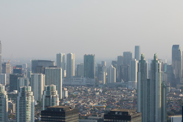 Fototapeta premium Jakarta, Indonesia - October 20, 2019: General aerial view of the skyline of the city of Jakarta, the capital of Indonesia, Java island, submerged by the dense smoke of pollution and the haze. 