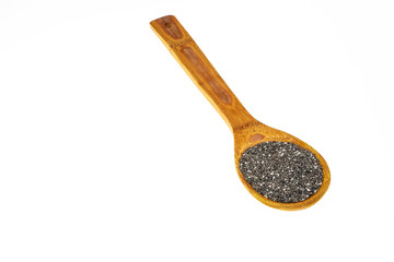 Large wooden spoon with raw chia seeds on white isolated background.