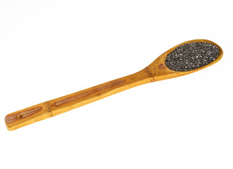 Large wooden spoon with raw chia seeds on white isolated background.