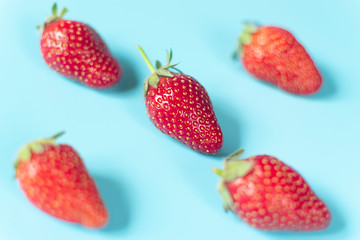 Fresh, red strawberries on light blue background