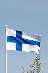 Fototapeta premium Finnish national flag on the wind against the blue sky