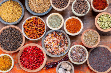 Indian spices collection, dried colorful condiment, nuts, pods and seeds and another spices in clay bowls