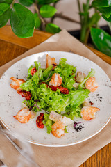 light healthy salad of fresh vegetables and shrimp. Photo in the interior