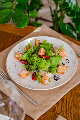 light healthy salad of fresh vegetables and shrimp. Photo in the interior