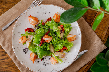 light healthy salad of fresh vegetables and shrimp. Photo in the interior