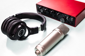 Condenser microphone and headphones, sound interface on blue table