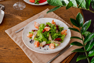 light healthy salad of fresh vegetables and shrimp. Photo in the interior