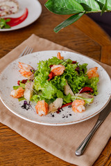 light healthy salad of fresh vegetables and shrimp. Photo in the interior