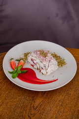beautiful tasty green vegan dessert pistachio strawberry rolls on a wooden table in the interior.