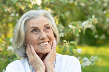 Portrait of senior smilling beautiful woman posing in spring park