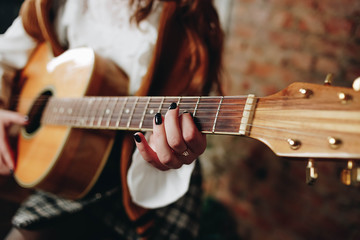 Hands of a young girl with a guitar closeup