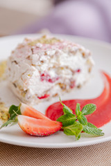 beautiful tasty green vegan dessert pistachio strawberry rolls on a wooden table in the interior.