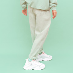 Hipster teen girl posing in studio. Urban style. Hip-hop. trendy shoes and jeans. Fresh fashion mint monochrome aesthetic colours.