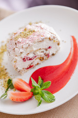 beautiful tasty green vegan dessert pistachio strawberry rolls on a wooden table in the interior.