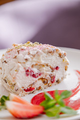 beautiful tasty green vegan dessert pistachio strawberry rolls on a wooden table in the interior.