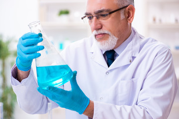 Fototapeta premium Old male chemist working in the lab