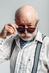 Elderly man with mustache poses in sunglasses