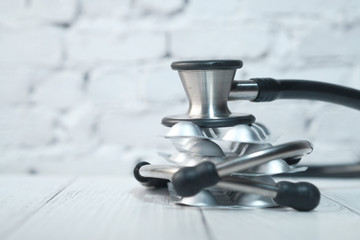 Close up of stethoscope and blister pack on table 
