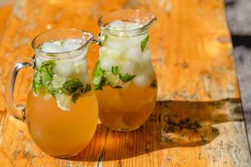 two mugs with mojito on wooden table