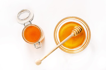Fototapeta na wymiar Glass jar and saucer with honey and a spoon for honey isolated on white background.