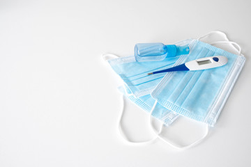 antiseptic and thermometer for the body lies on face masks